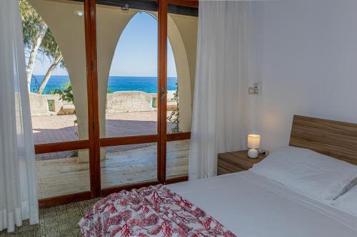 Un dormitorio con una cama y vista al mar. en Caminia - La baia incantata, en Caminia