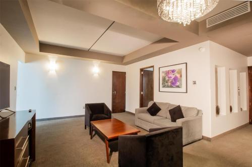 a living room with a couch and a table at Best Western Plus Santa Cecilia Pachuca in Pachuca de Soto