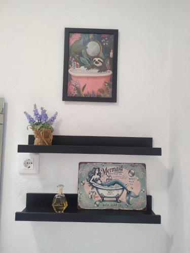 a shelf with a picture and a clock on a wall at Acera del Duende-Sardina in Gáldar