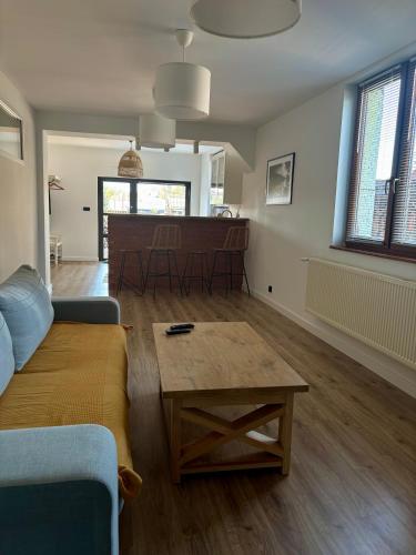 a living room with a couch and a coffee table at Apartament pod Świerkami in Pisz