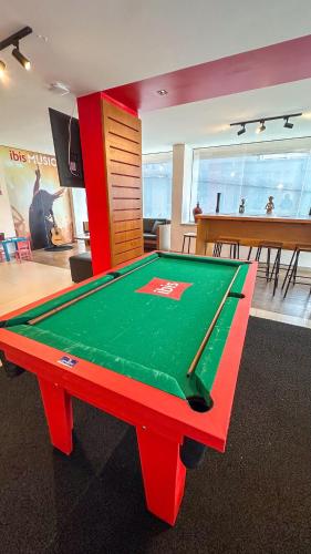 a ping pong table in a room with a dining room at ibis Maceio Pajuçara in Maceió