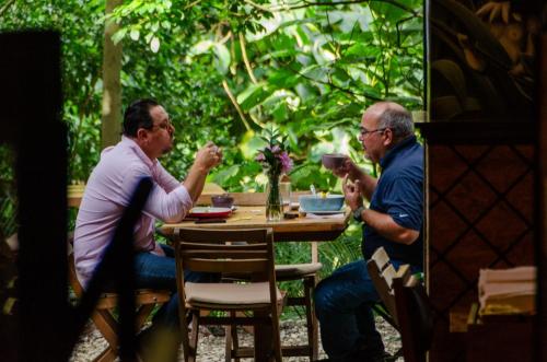 two men sitting at a table eating food at Rango Hostel Boutique in Medellín