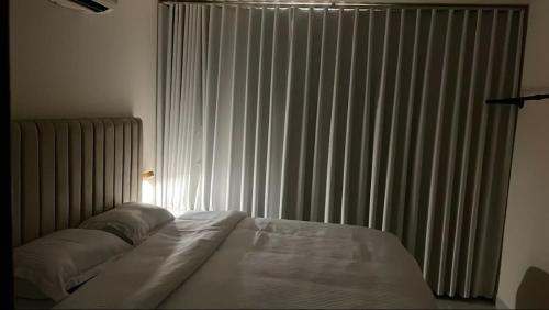 a bedroom with a bed and a window with curtains at 1BR, Living Room, Olaya in Al Khobar