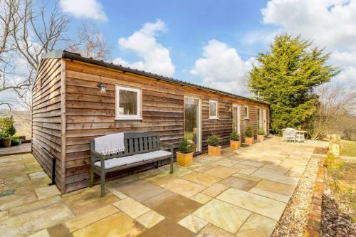 a tiny house with a bench on a patio at Treetops at Bewl Water in Wadhurst