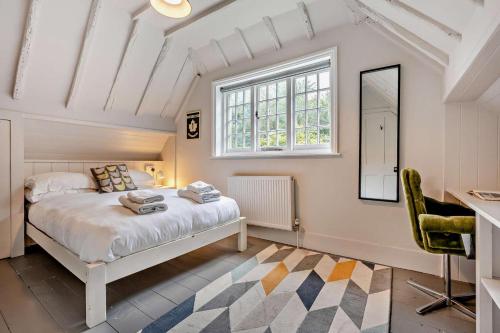 een slaapkamer met een bed, een bureau en een raam bij Castlemans Coach House in Sedlescombe