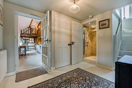 een hal met een deur naar een badkamer bij Castlemans Coach House in Sedlescombe