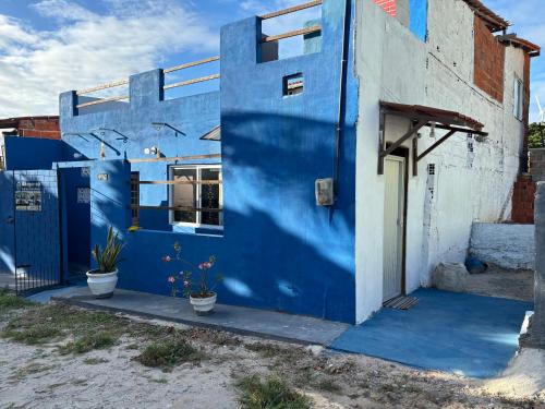 a blue building with two potted plants in front of it at Casa Cochilo na Rede in Beberibe