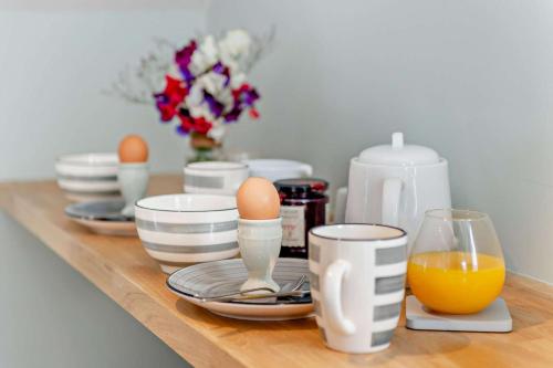 a table with eggs and plates and a glass of orange juice at The Barn - Chilham in Chilham