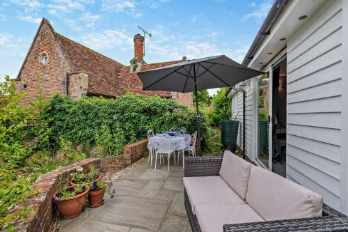 a patio with a table and an umbrella at The Barn - Chilham in Chilham
