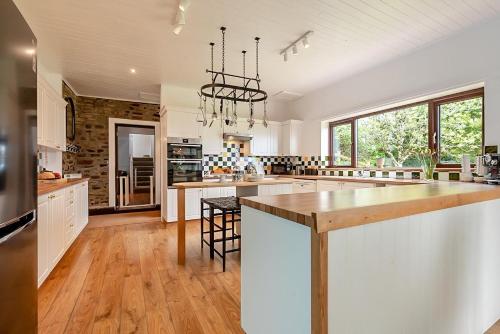 a large kitchen with white cabinets and a large island at Tumbles Lodge in Stratton