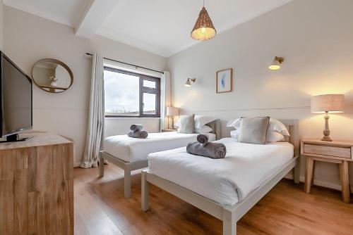a bedroom with two beds and a tv and a window at Tumbles Lodge in Stratton