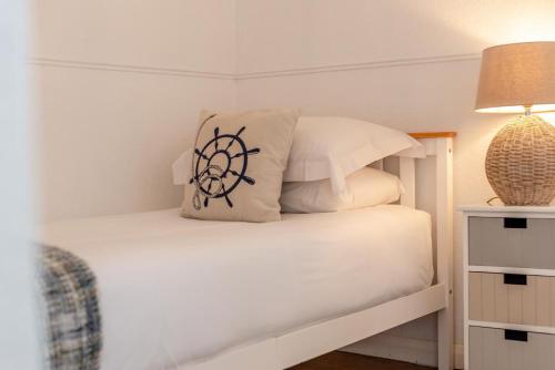 a bedroom with a white bed with a pillow on it at Tumbles Lodge in Stratton