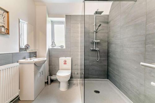 a bathroom with a shower and a toilet and a sink at Trevone in Saint Mawgan