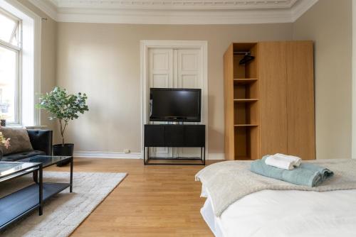 Una sala de estar con televisión y un sofá. en Oslo Living, en Oslo