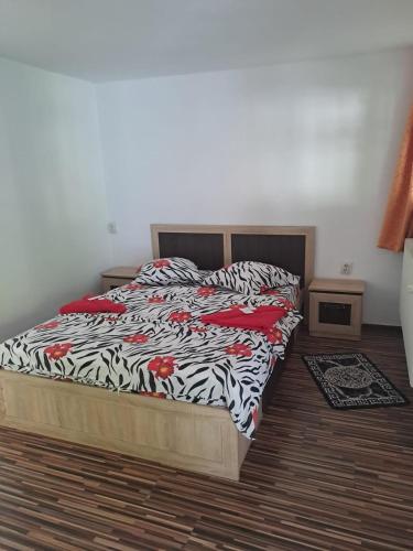 a bedroom with a bed with a zebra print blanket at Casa Cipri si Alex in Şimon