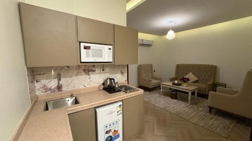 a kitchen with a sink and a living room at شقق سوار الذهب للشقق المخدومة in Sīdī Ḩamzah