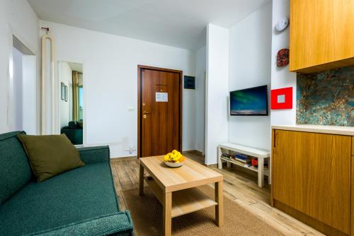 a living room with a green couch and a table at Arena Penthouse Apartments in Belgrade