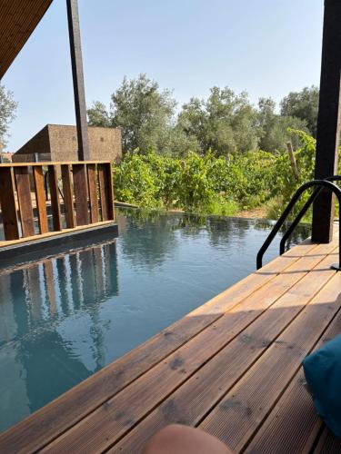 a wooden deck with a view of a river at D'Vine - Country house in Cartaxo