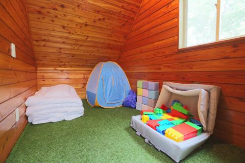 a room with a bed and two tents in it at Lala's Riverside Cabin in Tsumagoi
