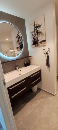 a bathroom with a sink and a mirror at Koselig leilighet i Mandal in Mandal