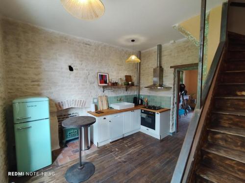 a kitchen with white cabinets and a blue refrigerator at Les Studios Grenouilles in Chasseneuil-du-Poitou
