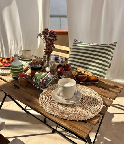 B&B Casa Uliva في كاستلانيتا: طاولة خشبية عليها طعام وقهوة