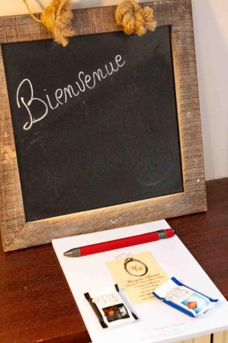 a chalkboard with the word elegance and a pen on a table at Marquise Barbot in Evry-Courcouronnes