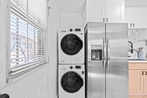 a kitchen with a washer and dryer next to a refrigerator at 20 percent OFF Fully Furnished 2BR in Prime Tustin in Tustin