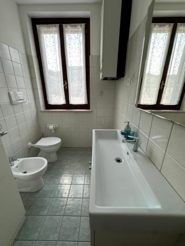 a white bathroom with a tub and a toilet at Locazione Turistica A Casa di Viola in Orvieto