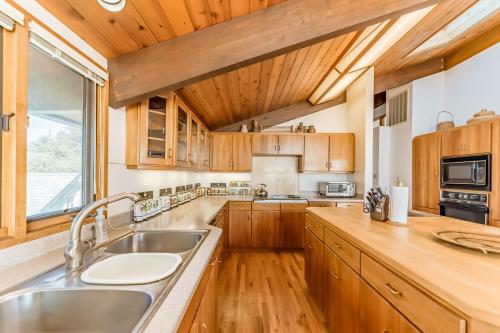 a kitchen with wooden cabinets and a large window at Crown of the Coast in Crescent City