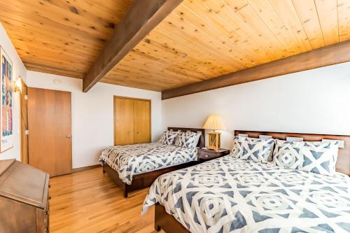 a bedroom with two beds and a wooden ceiling at Crown of the Coast in Crescent City