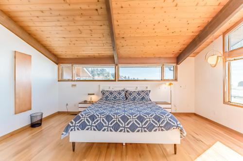 a bedroom with a bed and two windows at Crown of the Coast in Crescent City