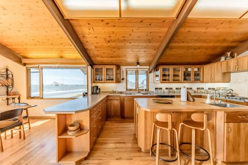 a kitchen with wooden cabinets and a large island with bar stools at Crown of the Coast in Crescent City