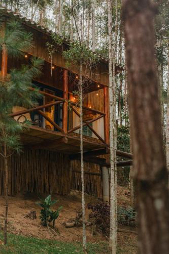 a wooden house in the woods with trees at Refúgio Com Hidro e Rede Suspensa Para Casais in Timbó