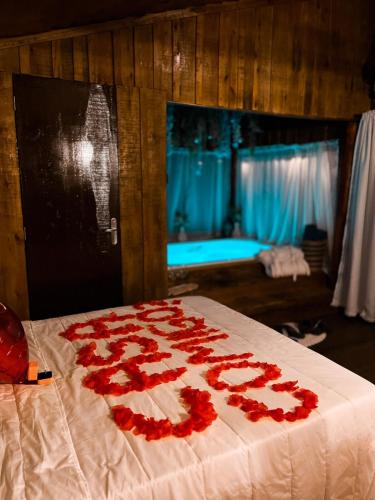 a bed with a bunch of red roses on it at Refúgio Com Hidro e Rede Suspensa Para Casais in Timbó