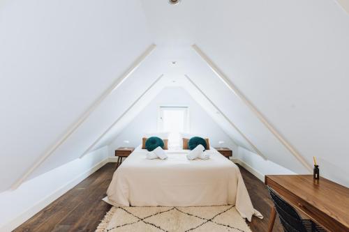 a bedroom with a white bed with two pillows at Staal House in Amsterdam