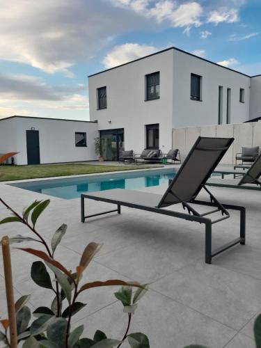 a house with a swimming pool in front of it at The Moment Luxury Suites in Parndorf