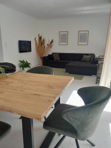 a living room with a wooden table and chairs at The Moment Luxury Suites in Parndorf
