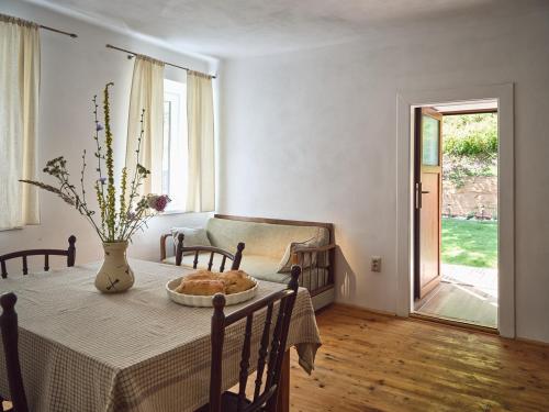 a dining room with a table with a vase on it at Chalupa pri Donovaloch so saunou in Motyčky