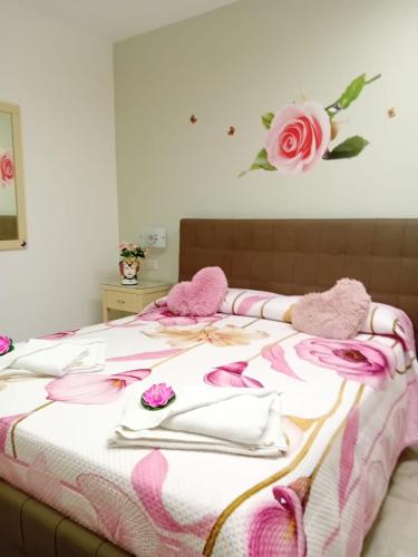 a bed with pink and white blankets and flowers on it at Al Punto Giusto in Catania