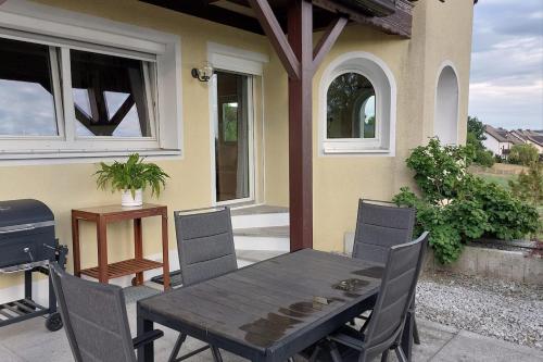 a wooden table and chairs on a patio with a grill at Wohnung in Selbitz in Selbitz