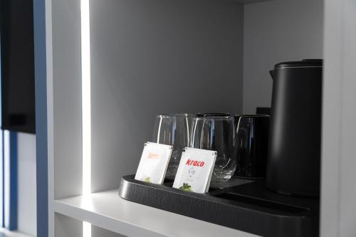 a shelf with wine glasses and a coffee pot at Erdeti Boutique Hotel in Sarandë