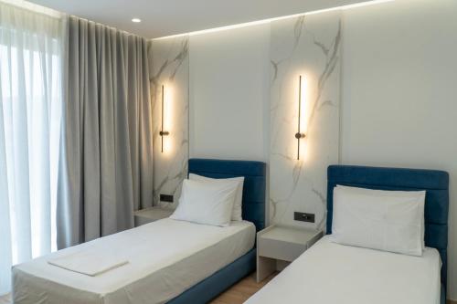a bedroom with two beds and a window at Erdeti Boutique Hotel in Sarandë