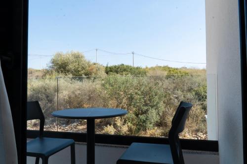 a table and chairs in front of a window with a view at Erdeti Boutique Hotel in Sarandë