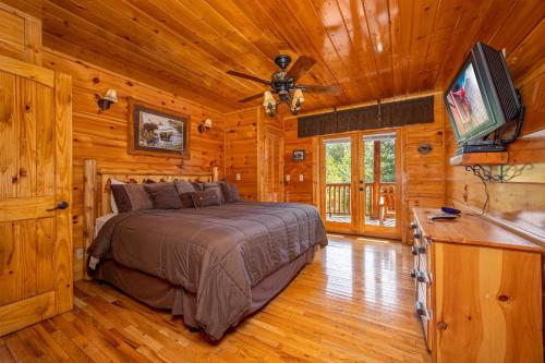 ein Schlafzimmer mit einem Bett und einem Flachbildfernseher in der Unterkunft The Great Outdoors by American Patriot Getaways in Little Cove