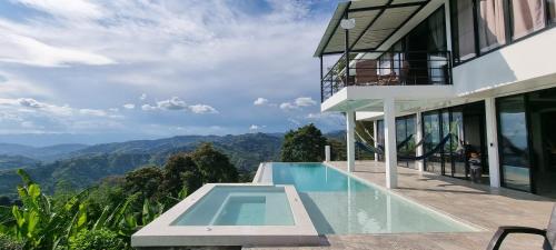 a house with a swimming pool and mountains in the background at Don Café - Luxury and confort in Manizales