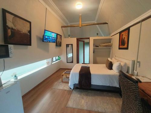 a bedroom with a bed and a tv on the wall at Lipizzaner Lodge - Kyalami, Midrand in Kyalami