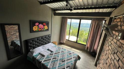 a bedroom with a bed and a large window at Don Café - Luxury and confort in Manizales