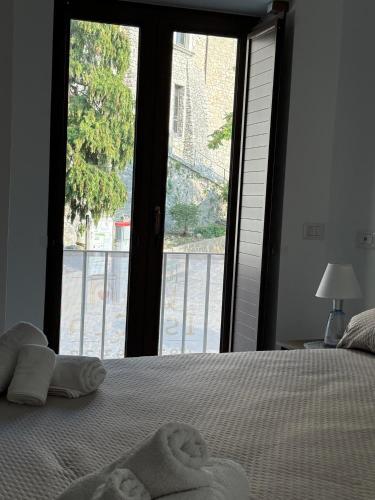 a bedroom with towels on a bed with a large window at Casa Vacanza IsaCla al Castello in Montemiletto