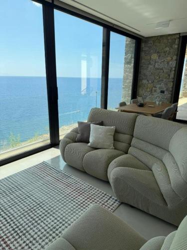 a living room with a couch and a view of the ocean at The Cliff in Melínta